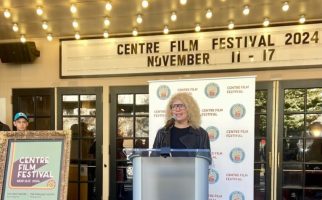 Pearl Gluck speaking at a podium outside of the State Theatre